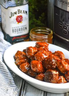 meatballs covered in bbq sauce on a white plate next to an instant pressure cooker