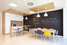 a chalkboard wall in the middle of a room with chairs and tables around it