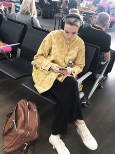 a woman sitting on a bench looking at her cell phone