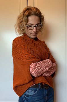 a woman wearing glasses leaning against a wall