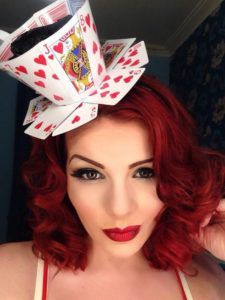 a woman with red hair wearing a white bra and a polka dot bow in her hair