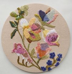 an embroidered floral design on a round surface