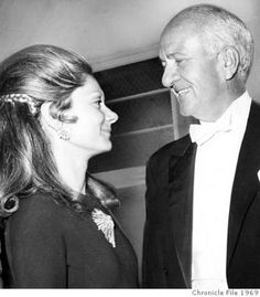 an older man and young woman are smiling at each other as they stand next to each other