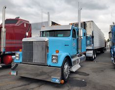 several semi trucks parked in a parking lot