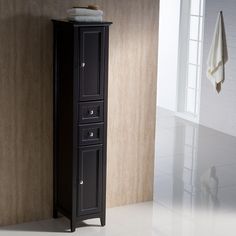 a tall black cabinet with two drawers in the corner next to a white towel rack