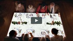 a group of people sitting around a table with plates and silverware on top of it