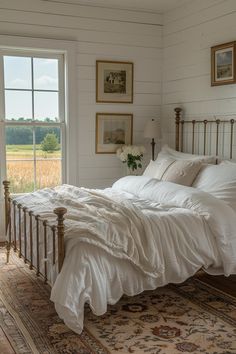 a bed with white linens and pillows in a bedroom next to a large window