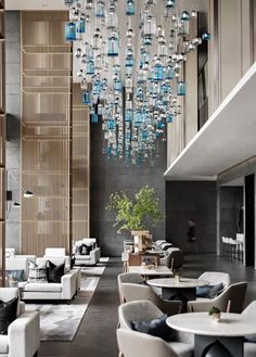 the lobby is decorated with modern furniture and glass chandelier hanging from the ceiling