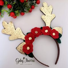 a close up of a mouse ears with flowers on it's head and antlers