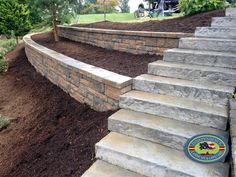 stone steps leading up to the top of a sloped garden area with mulch