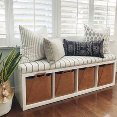 a white bench with storage baskets underneath it