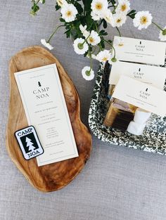 some white flowers are sitting on a tray next to some soaps and paper tags