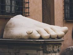 there is a large foot statue in front of a building