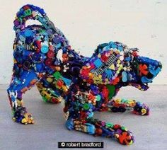 a dog made out of buttons and other things is shown in front of a white wall