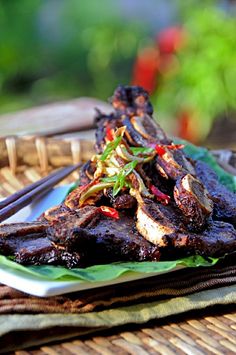 grilled meat on a plate with chopsticks