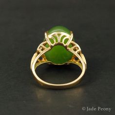 A statement piece that is bound to bring a vibrant and energetically enhanced essence to your days, this Statement Nephrite Jade Ring is both classic and contemporary. The center stone is a natural, untreated AAA nephrite jade stone of a statement-sized 11.75 carats, set in a four prong setting. With intricate details featuring 0.07 carats of sparking white diamonds on either side of the stone, this piece is set in a warm 18kt rose gold setting. Dimensions: Center Stone: Natural, untreated AAA N Formal Green Polished Gemstones, Elegant Emerald Jade Ring With Cabochon, Elegant Green Opal Ring Oval Cabochon, Elegant Green Opal Ring With Oval Cabochon, Elegant Oval Chrysoprase Rings, Elegant Jade Cabochon Rings, Elegant Jade Rings With Cabochon, Elegant Green Opal Ring In 14k Gold, Elegant Green Opal Oval Ring