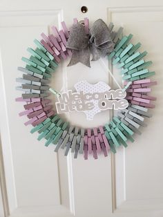 a wreath made out of clothes pins with the words welcome little one on it