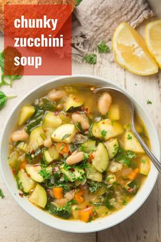 a white bowl filled with vegetable soup next to bread