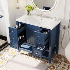 a bathroom with a sink, mirror and blue cabinetry on the floor in front of it