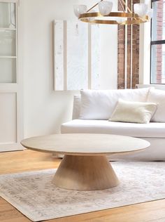 a living room with white couches and a round coffee table