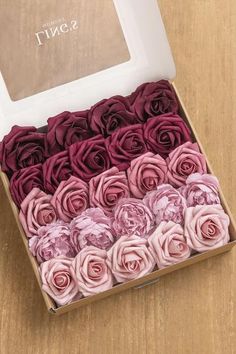 an open box filled with pink and purple flowers