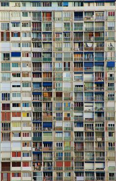 an apartment building with many windows and balconies on the sides, all in different colors