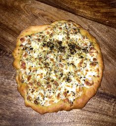 a pizza sitting on top of a wooden table covered in cheese and other toppings