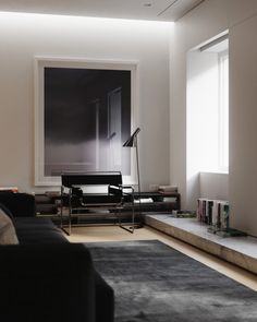 a living room filled with furniture and a book shelf in front of a large window