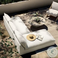 a white couch sitting on top of a wooden floor next to a table and chair