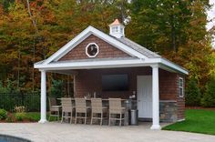 a backyard with a pool and gazebo surrounded by trees in the fall, including an outdoor dining area