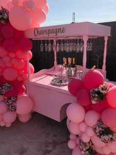 a table with balloons and wine glasses on it in front of a sign that says champagne