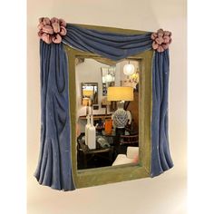 a mirror that is hanging on the wall next to a table with a lamp and vase