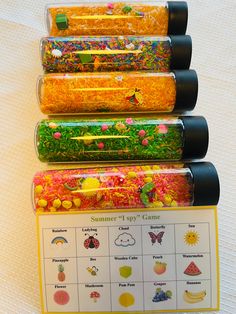 four plastic containers filled with different types of candy on top of a white tablecloth