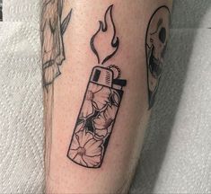 a tattoo with a lighter and flowers on it