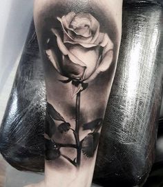 a black and white rose tattoo on the leg