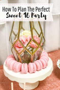 a cake with pink frosting and gold decorations on top is sitting on a table