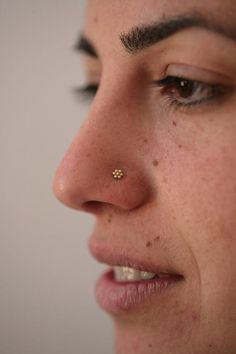 a close up of a woman's nose with a piercing in the middle of her nose