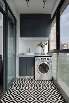 a washer and dryer in a small room with an open window overlooking the city