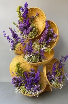 purple flowers are arranged in wicker baskets