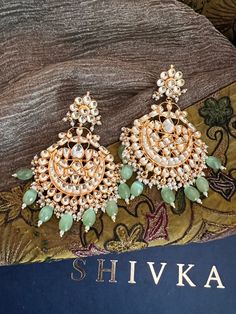 These gorgeous wedding Kundan earrings will add a perfect charm to your occasion wear. You will definitely fall in love with this beauty and it will make you stand out among the crowd. Pachi Kundan Length 9.5cms Width 6 cms Weight 68 grams a pair Traditional Green Hoop Earrings For Wedding, Fusion Chandbali Danglers For Wedding, Fusion Chandbali Wedding Danglers, Fusion Style Chandbali Danglers For Wedding, Fusion Style Chandbali Wedding Danglers, Green Bridal Earrings For Wedding, Festive Green Bridal Earrings For Wedding, Fusion Style Chandbali Chandelier Earrings For Wedding, Green Chandbali Danglers For Wedding