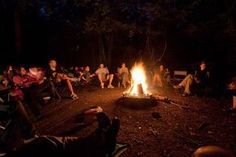 people sitting around a campfire at night