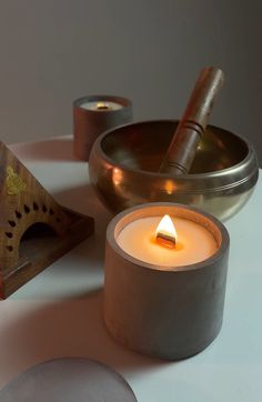 a candle sitting on top of a table next to other items that are around it