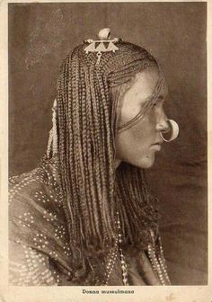 an old black and white photo of a woman with long braids