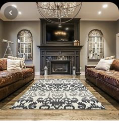 a living room with two couches and a chandelier in the middle of it