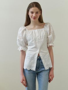 This clothing item is a dress with dramatic puff sleeves and an off-the-shoulder neckline. It features a button-up front and is adorned with eyelet lace detailing throughout, providing a see-through effect on the sleeves and hem. The hemline showcases a scalloped edge, enhancing the dress's feminine charm.- The eyelet lace detailing creates a delicate and airy feel, perfect for warm weather.- Its off-the-shoulder design and puff sleeves add a trendy and romantic touch.- The scalloped hemline con Spring Square Neck Top With Broderie Anglaise, Spring Eyelet Blouse With Puff Sleeves, Fitted Blouse With Broderie Anglaise, Fitted Broderie Anglaise Blouse, Chic Fitted Eyelet Blouse, Feminine Puff Sleeve Blouse With Broderie Anglaise, Summer Eyelet Blouse With Puff Sleeves, Spring Eyelet Blouse For Daywear, Feminine Summer Eyelet Blouse