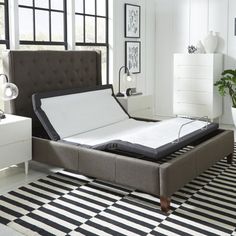 a bed that is sitting on top of a black and white rug