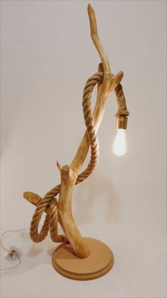 a lamp that is on top of a wooden base and has rope wrapped around it