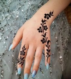 a woman's hand with black flowers on it