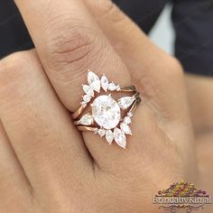 a woman's hand with a diamond ring on top of her finger and an engagement band