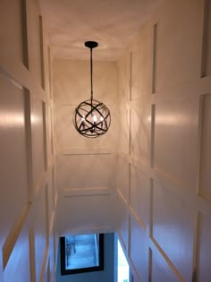 a light hanging from the ceiling in a hallway